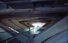 an escalator in a building with people walking down it