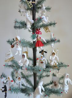 a small christmas tree with many ornaments on it's branches and decorations hanging from the top