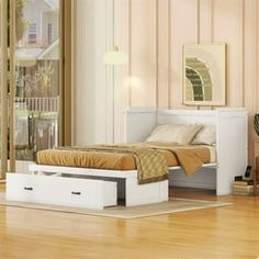 a white bed sitting on top of a hard wood floor next to a wooden table