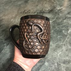 a hand holding a coffee mug with an octopus on it