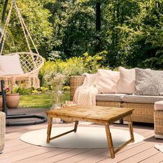 a wooden table sitting on top of a patio next to a hammock chair