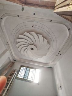 a person is pointing at the ceiling in an unfinished room