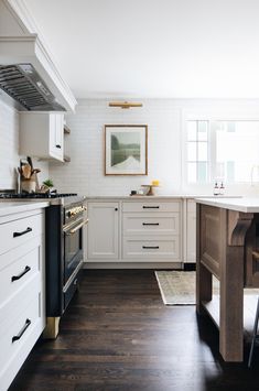 the instagram page shows an image of a kitchen with white cabinets and wood floors