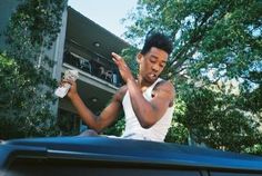 a man sitting in the back of a car waving to someone with his hand out