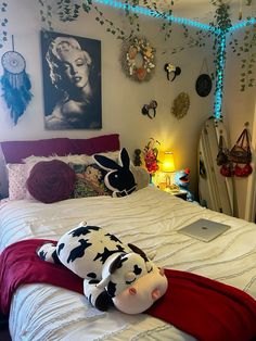 a stuffed animal laying on top of a bed in a room with pictures above it