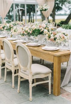 the table is set with white and pink flowers