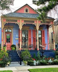 a colorful house with red and blue shutters on the front porch is pictured in this image