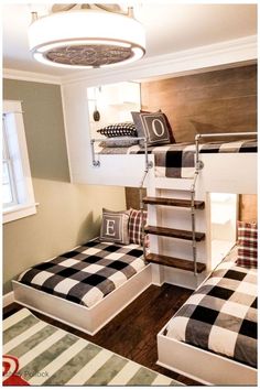 two bunk beds with checkered pillows in a small child's room, one on top of the other