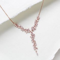 Our breath-taking rose gold bridal Y necklace is perfect for your special day. The necklace features a unique Y-shaped design, with an eye-catching array of small stones, making it a must-have for any bride. Its timeless design is perfect for creating lasting memories. - Created with Premium Cubic Zirconia stones - Available in rose gold, yellow gold, and rhodium finish. - Necklace pictured measures 16 inches and extends to 18 inches  - Decorative vine portion measures 4 inches, drop in center i Rose Gold Delicate Bridal Necklace For Formal Occasions, Delicate Rose Gold Bridal Necklace For Formal Occasions, Rose Gold Wedding Necklace With Elegant Design, Delicate Rose Gold Drop Necklace For Wedding, Rose Gold Clavicle Chain Necklace For Wedding, Delicate Rose Gold Bridal Necklace For Party, Dainty Rose Gold Bridal Necklace For Anniversary, Rose Gold Lariat Necklace For Party, Rose Gold Lariat Jewelry For Wedding