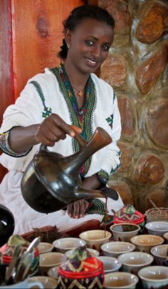 a woman is pouring tea into her cup