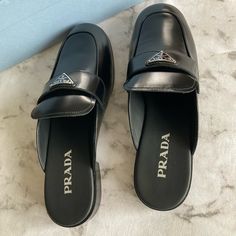 Prada Milano Calzature Donna Slip On Backless Loafers Brand New In Box Make An Offer Black Calf Leather Mules With Leather Footbed, Black Slip-on Mules In Calf Leather, Black Slip-on Calf Leather Mules, Luxury Almond Toe Slip-on Mules, Designer Mules With Leather Footbed For Work, Designer Mules For Workwear With Leather Footbed, Luxury Flat Mules For Formal Occasions, Designer Workwear Mules With Leather Footbed, Luxury Formal Flat Mules