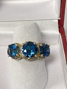 This is a very pretty ring we made years ago. The ring was recently traded in and we put the 3 new blue topaz in it. The ring weighs 6.8 grams and makes a nice bold impressions, and is in very good shape Fine Jewelry Blue Three Stone Jewelry, Blue Topaz Three Stone Blue Jewelry, Fine Jewelry Blue Topaz Three Stone Ring, Topaz Ring With Diamond Accents, Anniversary Topaz Jewelry With Three Stones, Anniversary Three-stone Blue Topaz Jewelry, Anniversary Three Stone Blue Topaz Jewelry, Three Stone Blue Topaz Jewelry For Anniversary, Dazzling Blue Topaz Ring With Accent Stones