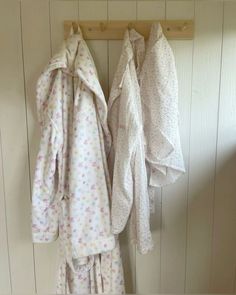 two robes hanging on a coat rack in a bathroom