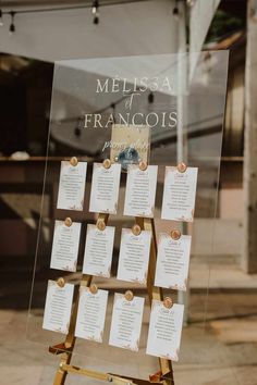 a wooden easel with seating cards attached to it