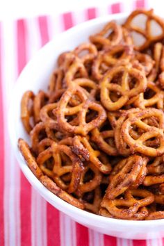 a white bowl filled with pretzels on top of a red and white striped table cloth