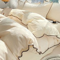 an unmade bed with white sheets and pillows