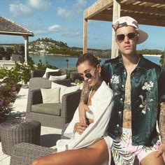 a man and woman sitting on a patio next to each other wearing matching outfits with tattoos