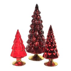 three red glass christmas trees sitting next to each other