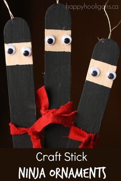 popsicle puppets with googly eyes and a red ribbon tied around the ends, hanging from clothes pins