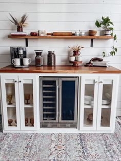 a kitchen with white cabinets and wooden counter tops on top of carpeted flooring