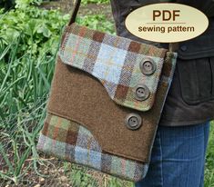 a woman is holding a brown and blue plaid purse with buttons on it's side