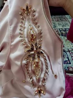 the back of a woman's pink dress with gold beading