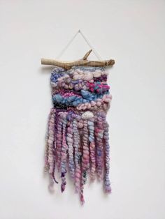 a wall hanging made out of yarn and beads