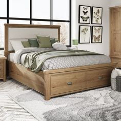 a wooden bed sitting in a bedroom next to a dresser and window with pictures on the wall