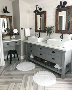 a bathroom with two sinks, mirrors and rugs on the floor in front of them