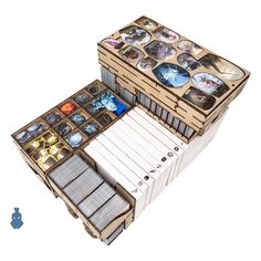 an open box with several cards inside it and a game board in the bottom right corner