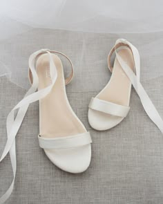 the bride's shoes are all white and have straps on each shoe, which is tied