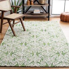 a green and white rug in a living room next to a wooden chair with a plant on it