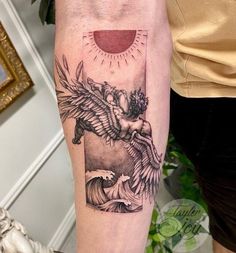 a woman's arm with a tattoo on it that has an eagle and sun in the background