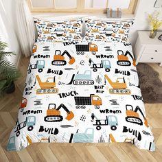 a bed with construction themed sheets and pillows