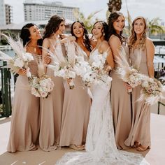 a group of women standing next to each other in front of a body of water