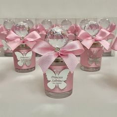 several small glass bottles with pink bows and labels on them, all lined up in a row