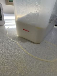 a plastic container sitting on top of a counter next to a thermostaer