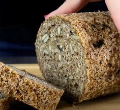 a loaf of bread sitting on top of a cutting board next to two slices of bread