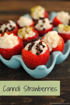 some strawberries with cream and chocolate on top are sitting in a blue dish that says cannoi strawberries