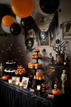 a table topped with lots of halloween decorations and balloons in the shape of pumpkins