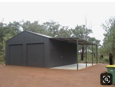 a large metal building sitting on top of a dirt road