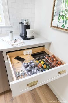 an open drawer in the middle of a kitchen