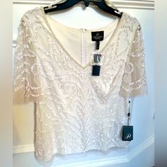 Add Some Much Needed Sparkle To Your Holiday Celebrations With This Elegant Adrianna Papell Beaded Ivory Top. It Is Lined, A Size 12, It Fits Beautifully. While It Coordinates Well With The Pictures Black And Ivory Skirt, It Is Being Sold Separately. Spring Formal Beaded Tops, Elegant Cream Embellished Tops, Elegant Beaded Tops For Wedding, Elegant Beaded Tops For Spring, Elegant Beaded Short Sleeve Tops, Elegant Beaded V-neck Tops, White Off Shoulder Top, Ivory Skirt, Wrap Top Blouse