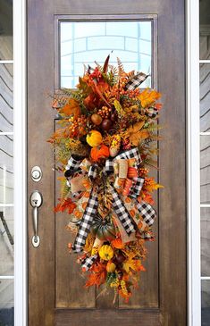 a front door decorated with fall leaves and pumpkins