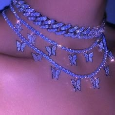 the back of a woman's neck with butterflies on it and chains attached to her chest