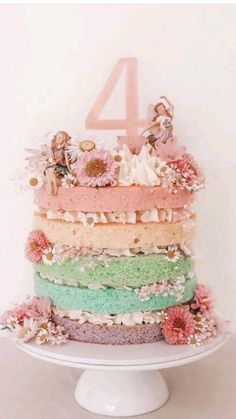 a multi layer cake sitting on top of a white plate next to a number four sign