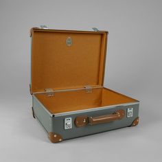 an open suitcase sitting on top of a gray floor next to a white wall in the background