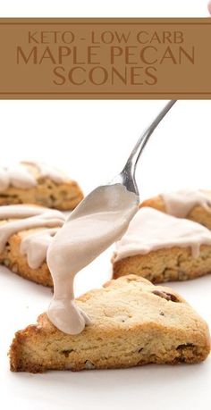 a spoon is being drizzled with white icing on some scones