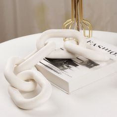 a white table topped with a book and chain