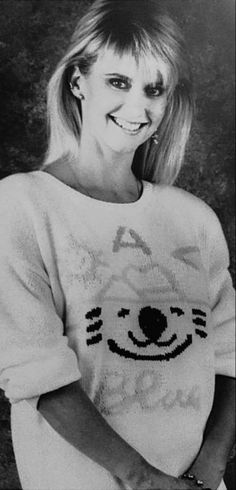 a black and white photo of a woman wearing a sweater with a cat on it